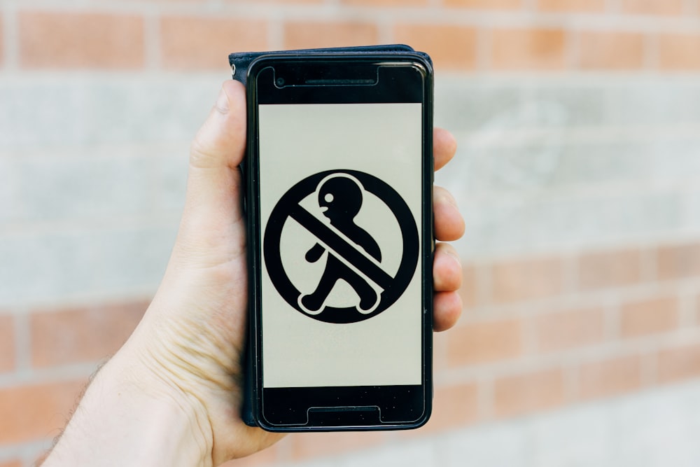 person holding black smartphone with black and white case