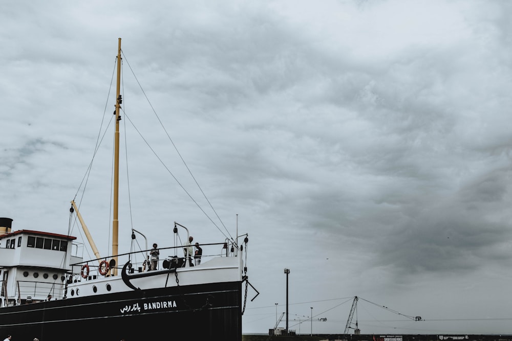 white and black boat on sea under gray sky