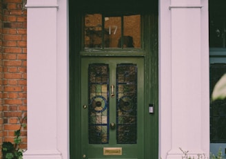 green wooden door with glass