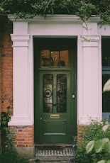 green wooden door with glass