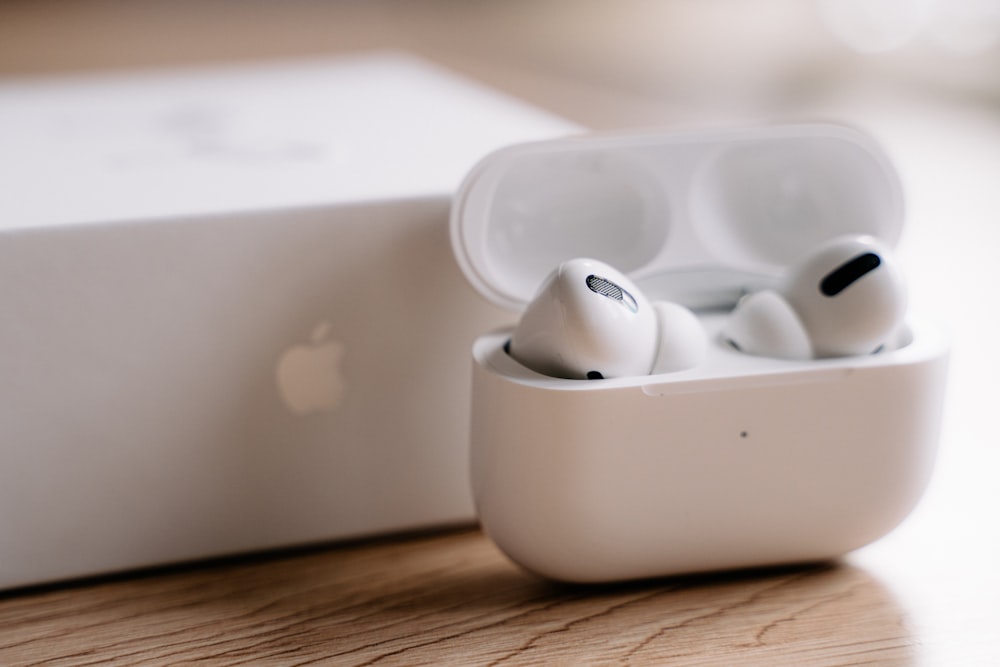 흰색 플라스틱 케이스에 있는 백색 사과 earpods