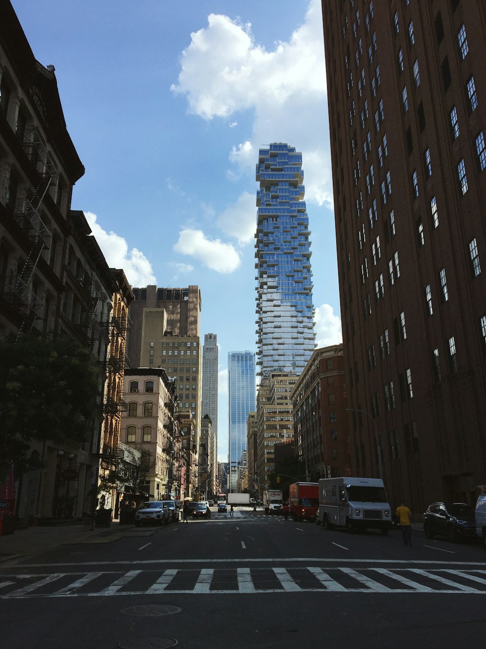 cars on road near high rise buildings during daytime