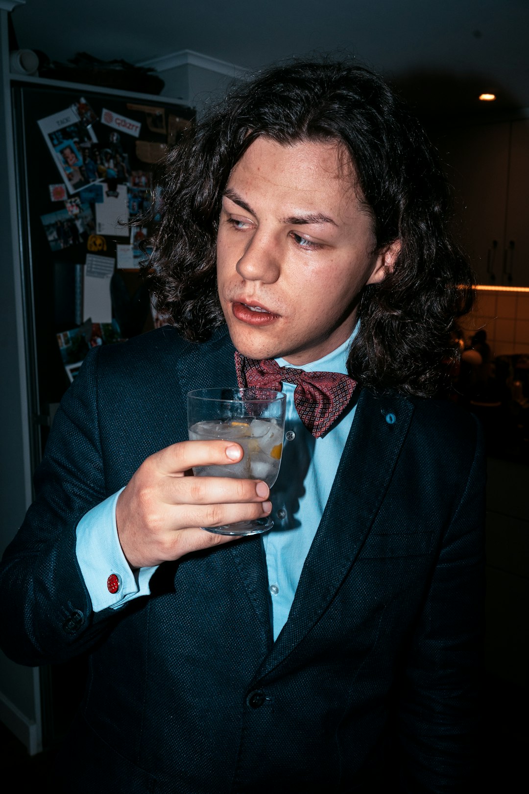 woman in blue blazer holding drinking glass