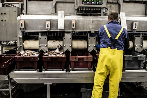 man in yellow pants standing in front of food display