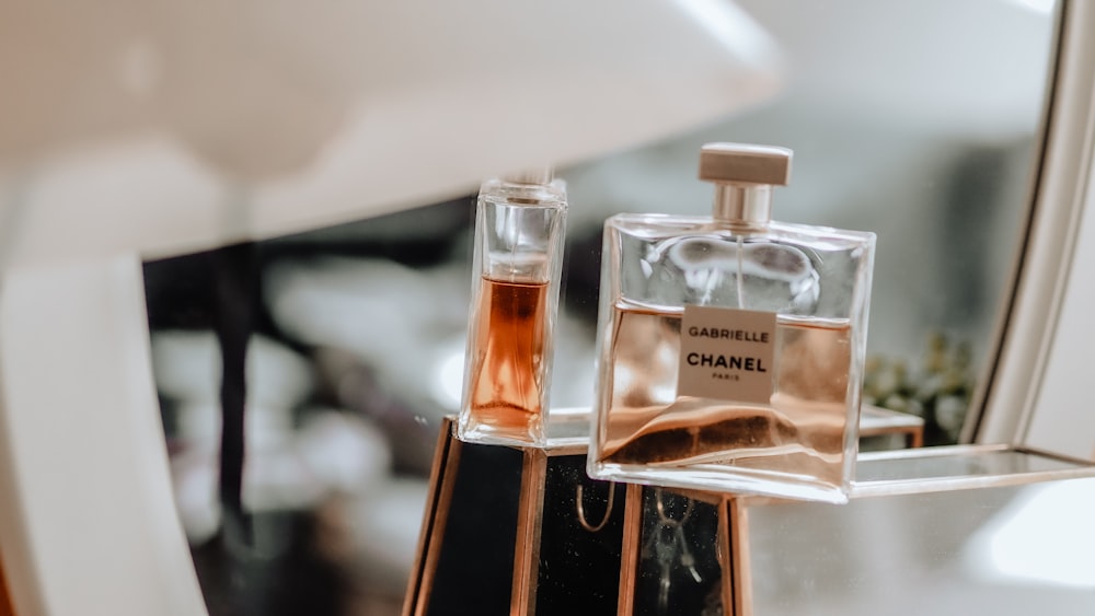 clear glass perfume bottle on white table