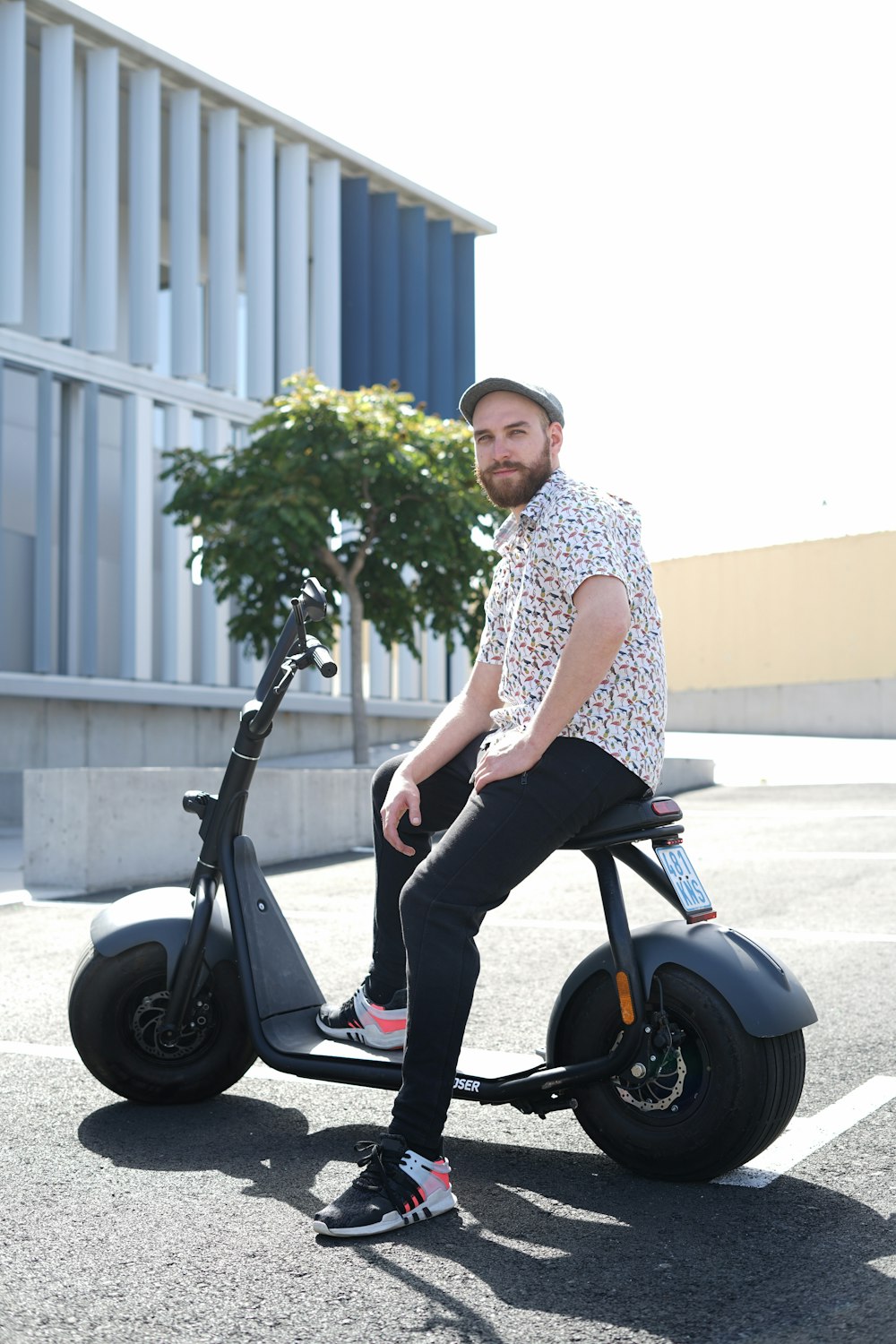 man in white and black checkered dress shirt and black pants sitting on black motorcycle during