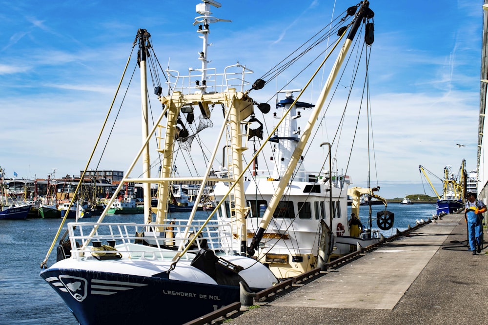 Barco blanco y azul en el muelle durante el día