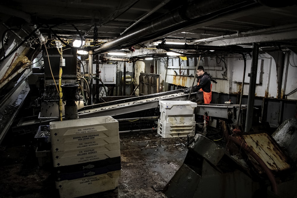 man in black t-shirt standing near industrial machine