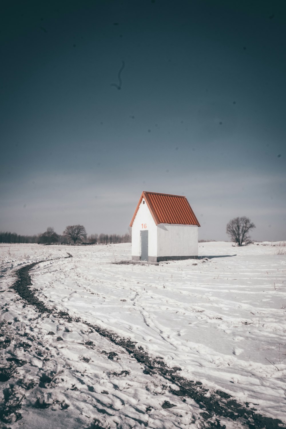 white and red house on snow covered ground