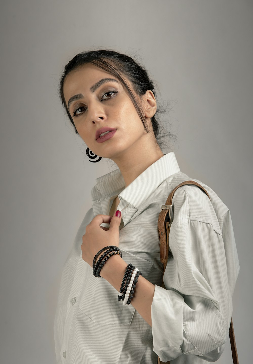 woman in white dress shirt wearing black and silver beaded necklace