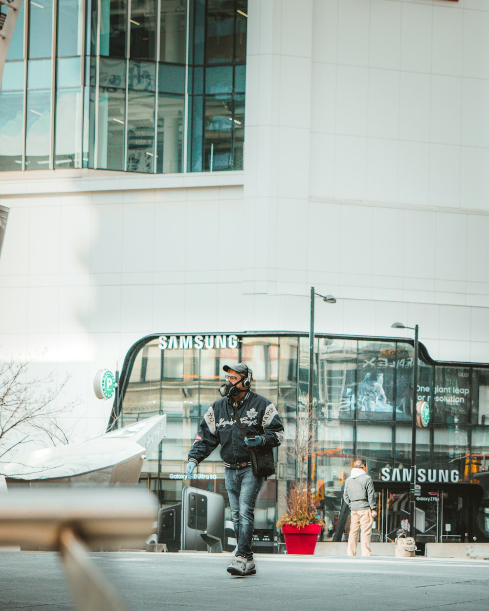 uomo in giacca nera e pantaloni neri seduto sulla panca d'acciaio nera durante il giorno