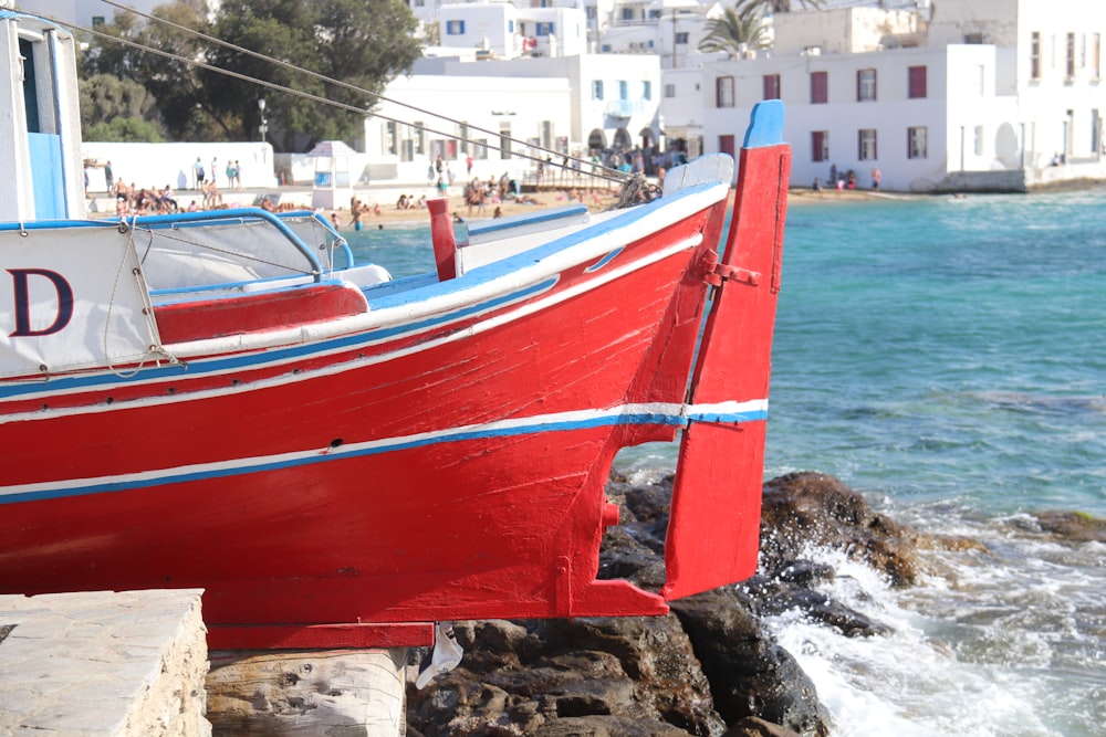 red and white boat on sea shore during daytime