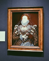 A vintage portrait of an ancestor in traditional noble attire, framed in gold.