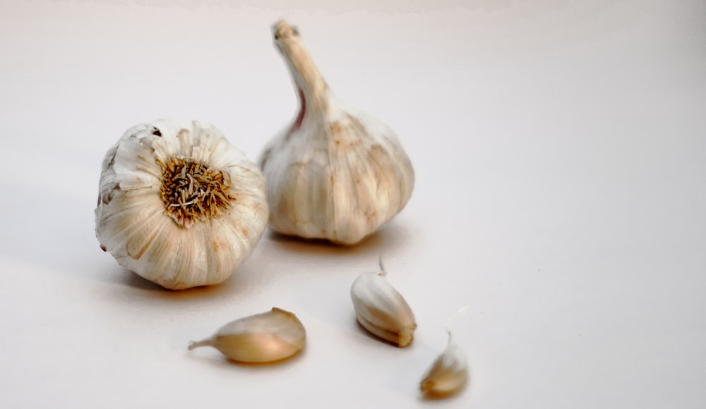 garlic bulb and garlic on white surface