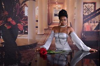 Elegant woman wearing a rose gold dress standing confidently in a softly lit room