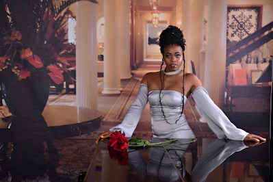 Elegant woman wearing a rose gold dress standing confidently in a softly lit room