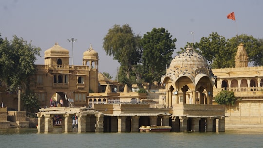 white concrete building near body of water during daytime in Rajasthan India