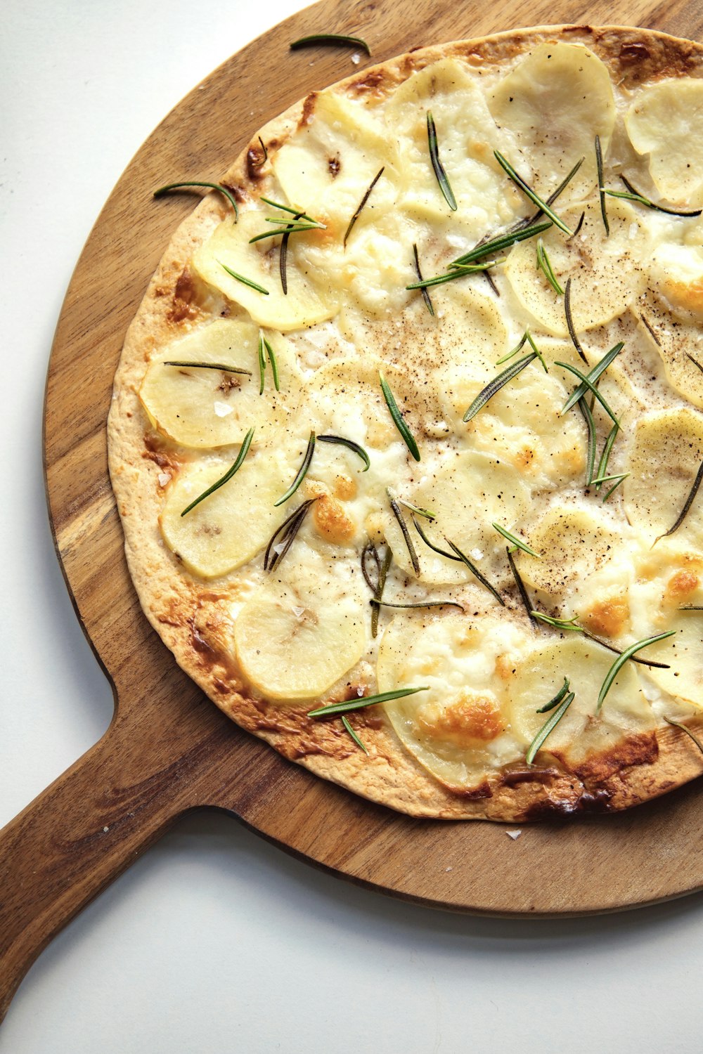 uma pizza sentada em cima de uma tábua de corte de madeira