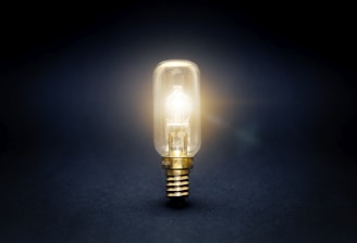 yellow light bulb turned on on blue surface