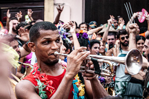 A lively workshop with trumpet players gathered around a teacher demonstrating techniques