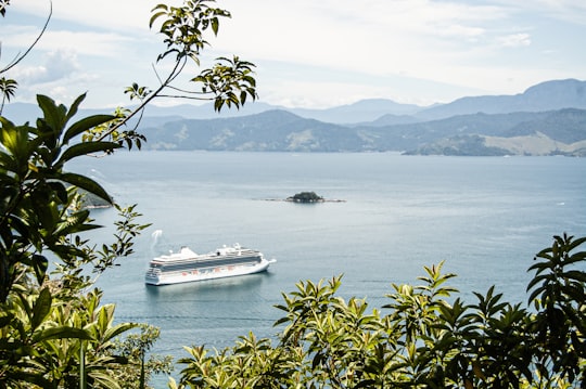 white and black boat on sea near mountain during daytime in Ilha Grande Brasil