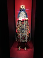 A vibrant festive wear ensemble displayed on a mannequin, showcasing detailed beadwork and rich textures.