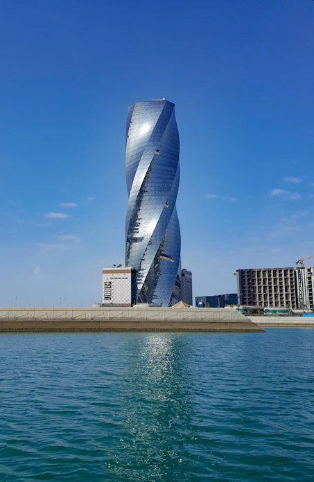 blue glass building near body of water during daytime