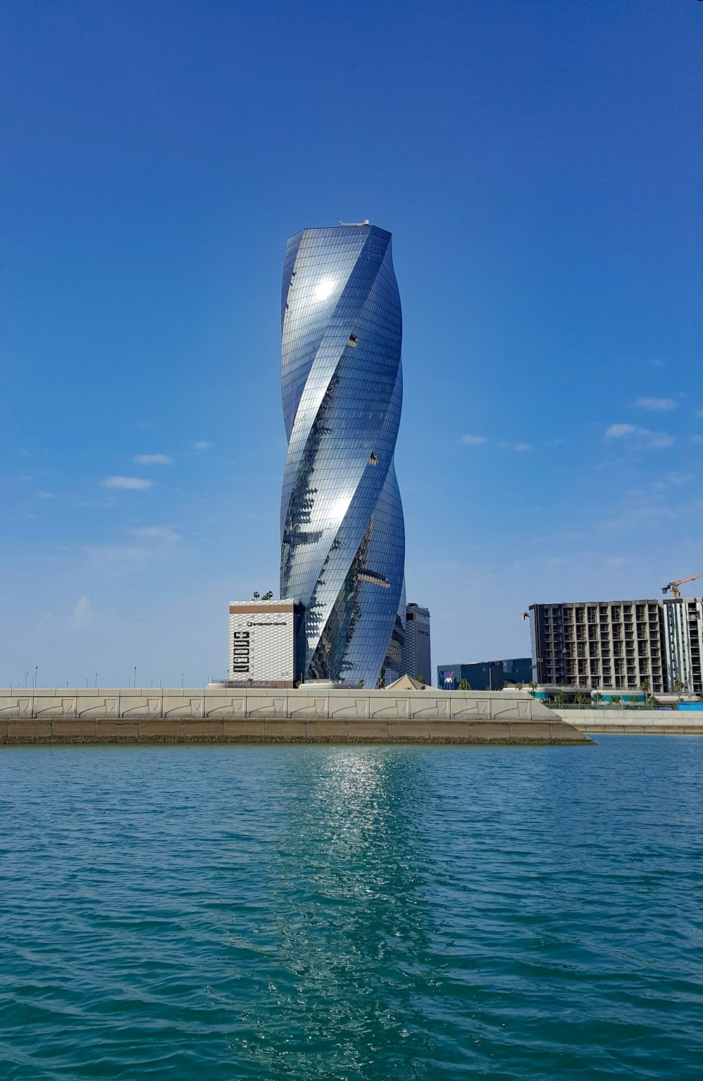 Edificio de vidrio azul cerca del cuerpo de agua durante el día