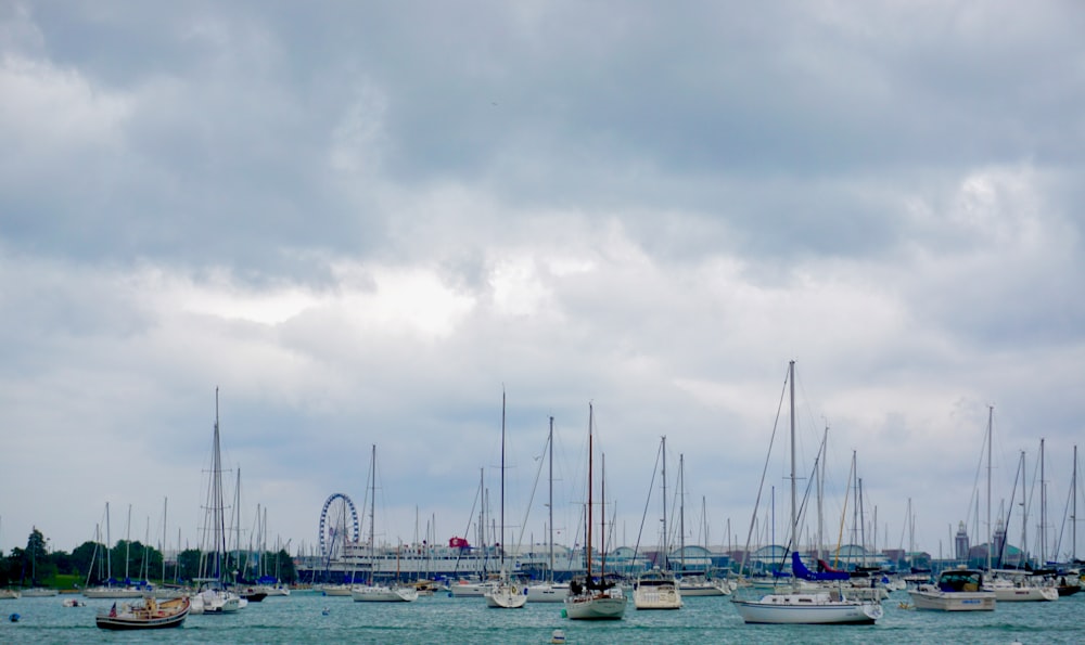 white and blue boats on sea under gray sky