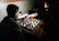 Two players intensely focused on a Magic: The Gathering duel in a dimly lit, atmospheric room.