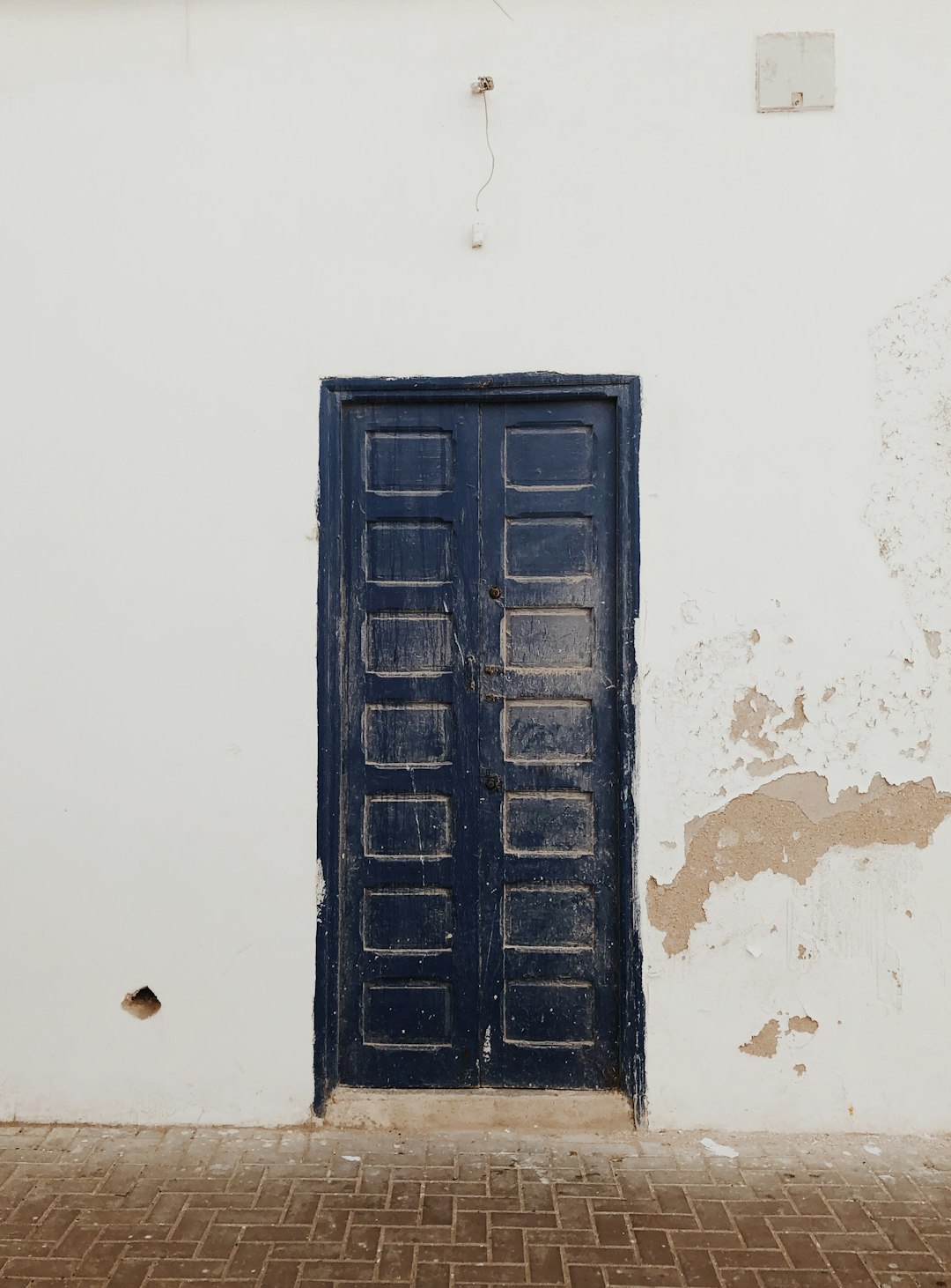 black wooden door on white concrete wall