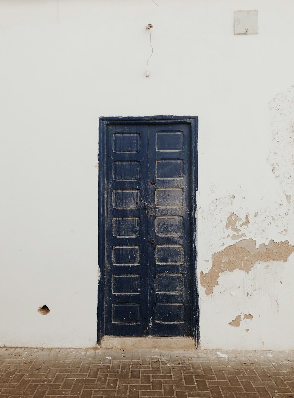 Porte en bois noir sur mur en béton blanc