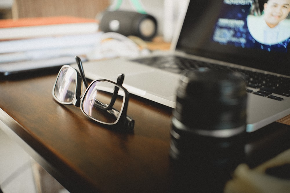 black framed eyeglasses on brown wooden table