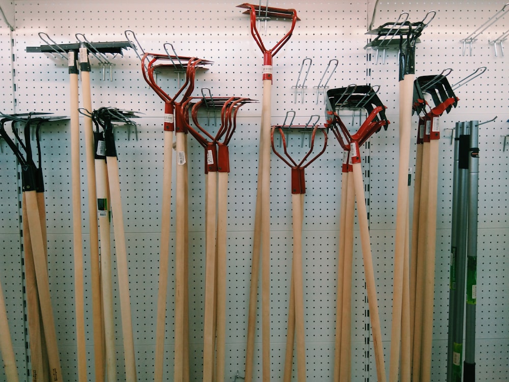 red and brown shovel leaning on white and brown bamboo sticks