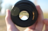 Close-up of a camera lens capturing a dynamic outdoor scene during a shoot.