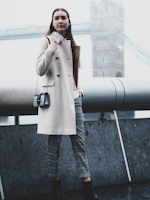 A model walking confidently down a bustling city street wearing a stylish, tailored coat from the collection.