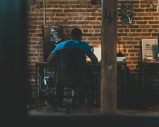 man in blue shirt sitting on black chair