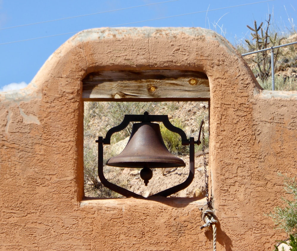 Campana negra en pared de hormigón marrón