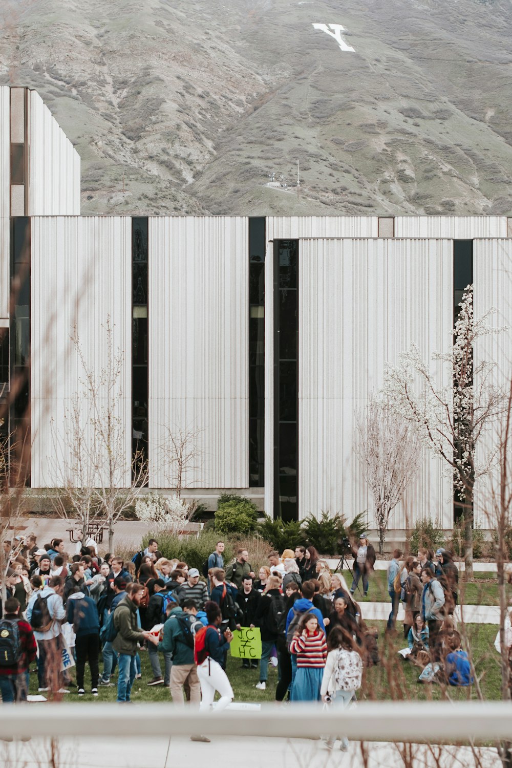 people sitting on brown grass field near white concrete building during daytime