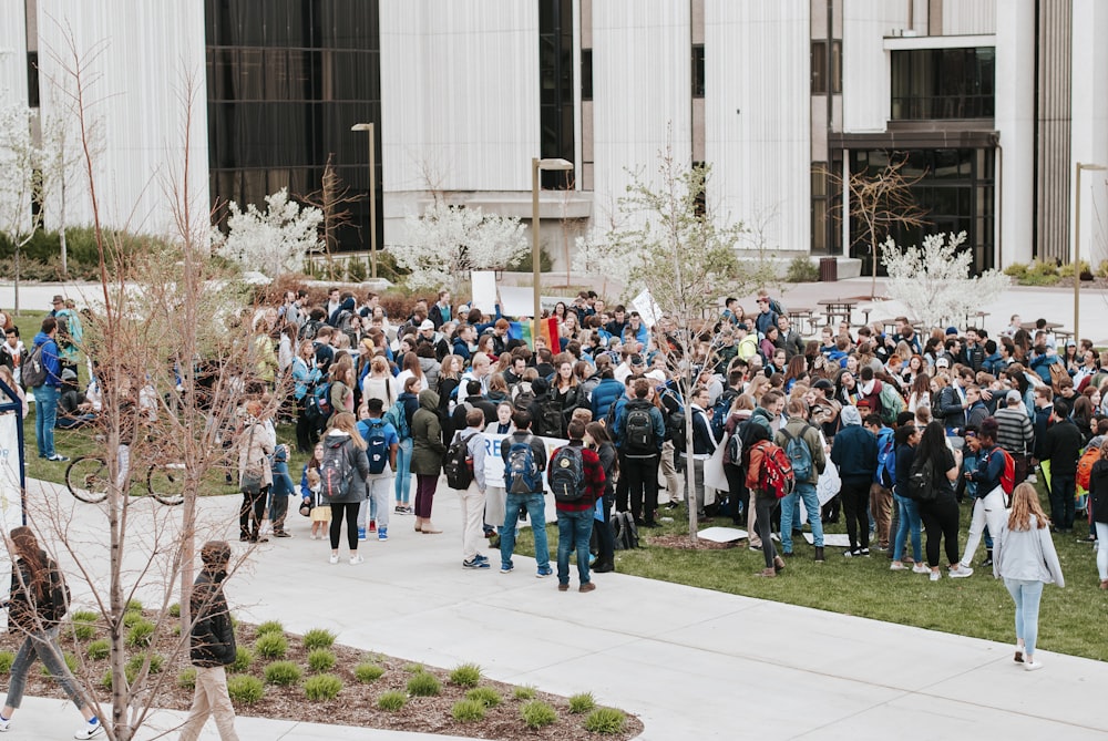 people in blue shirts standing on white floor tiles during daytime