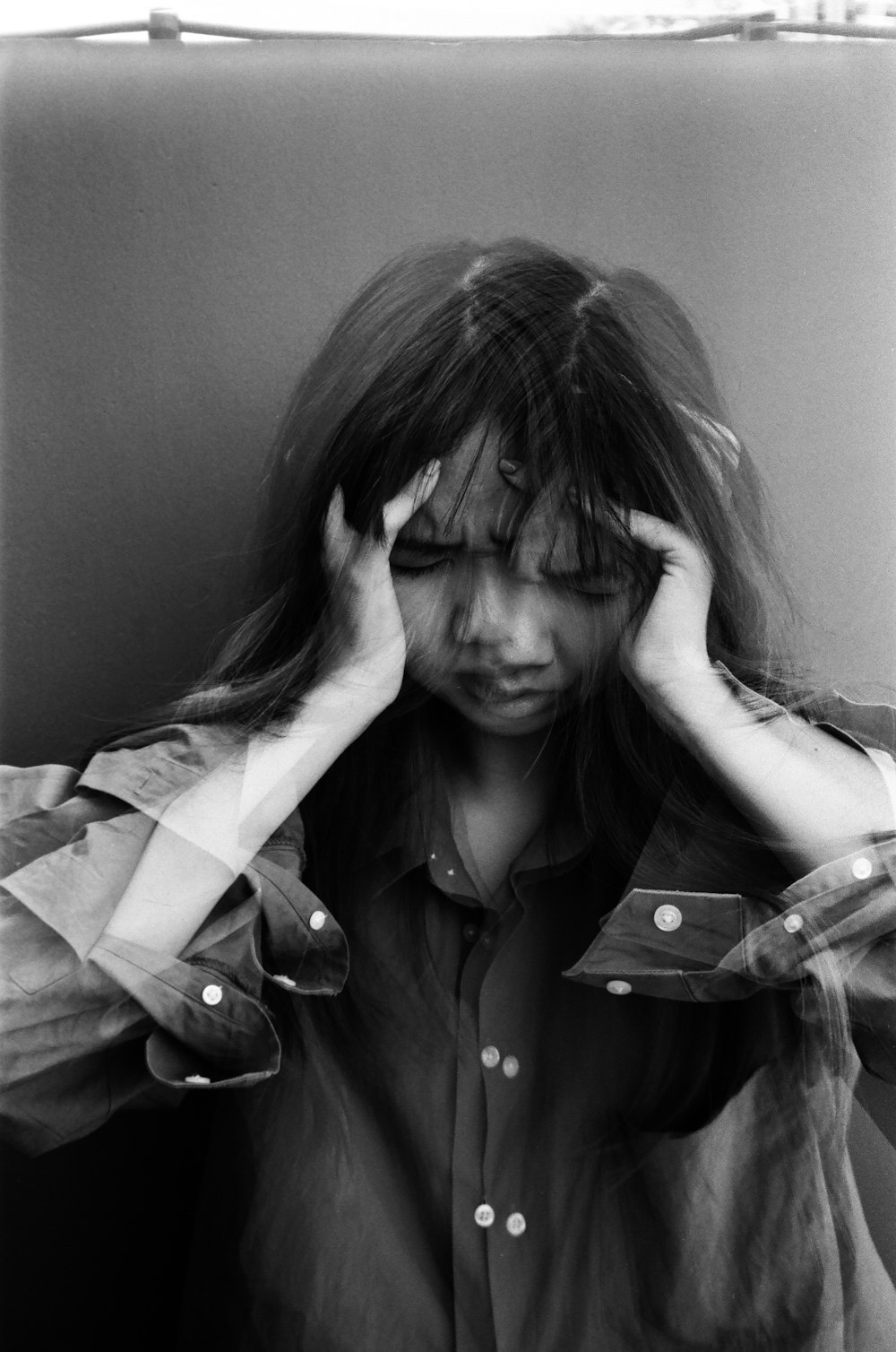 grayscale photo of woman covering her face with her hair