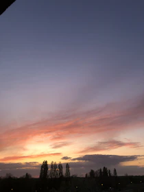 A serene sunset behind Ebenru singing outdoors, symbolizing inspiración y paz.