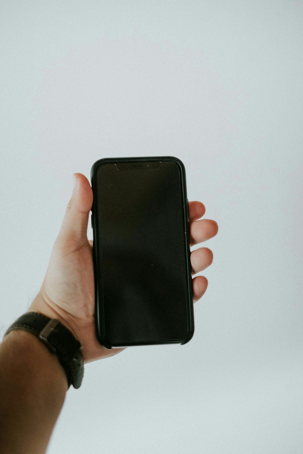 person holding black iphone 5 c