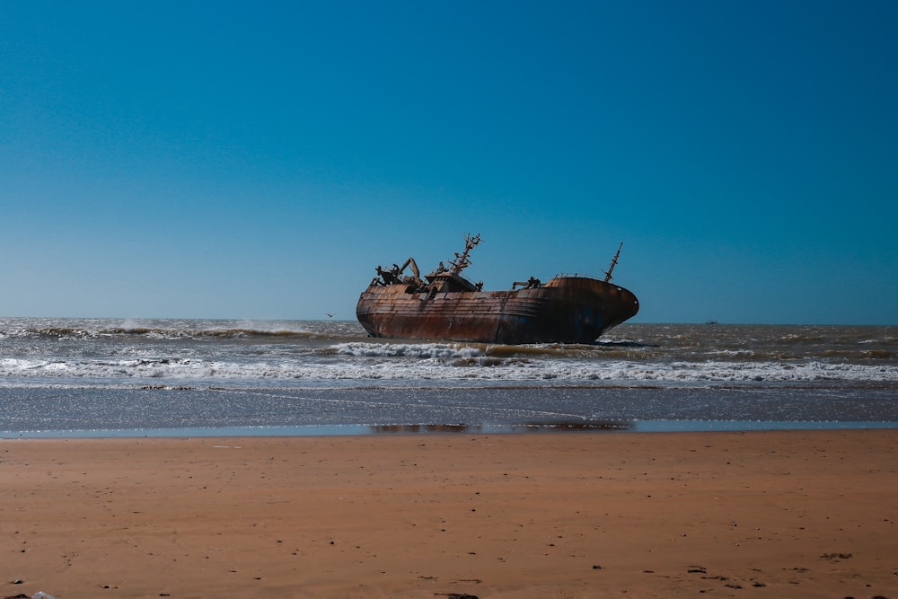 navire brun sur le rivage de la mer pendant la journée