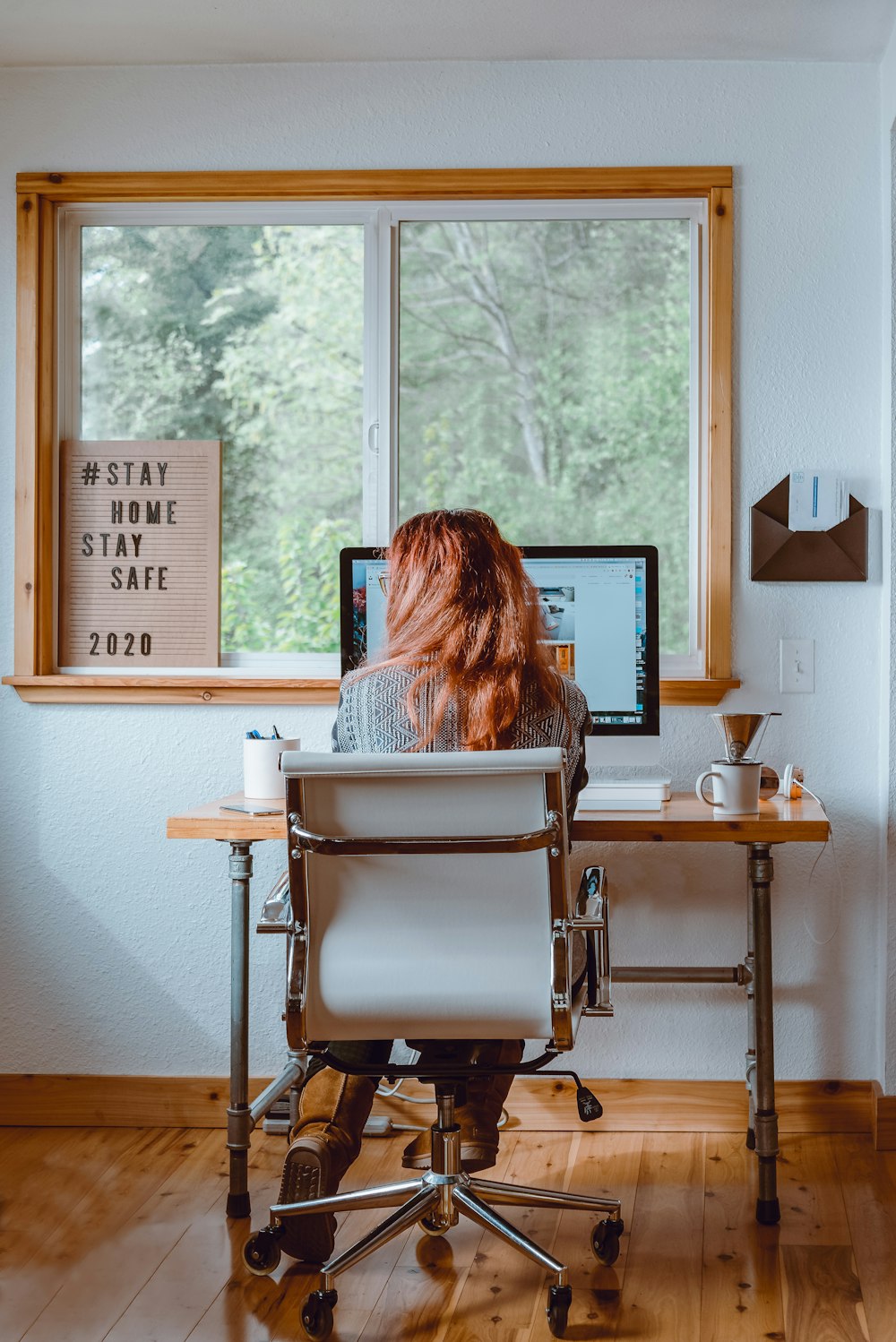 woman sitting on white and black chair in front of brown wooden table