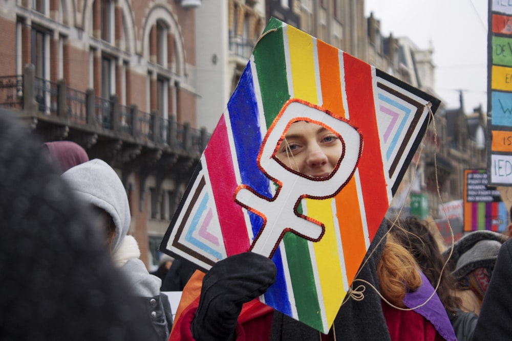 woman in black jacket holding multi colored heart shaped paper