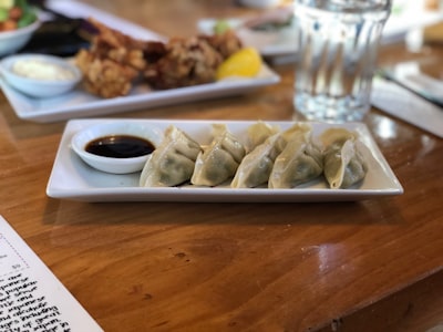 white ceramic plate on brown wooden table dumpling google meet background