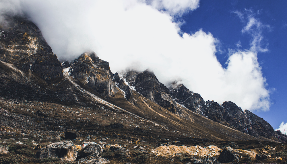 brown and gray mountain under white clouds and blue sky during daytime