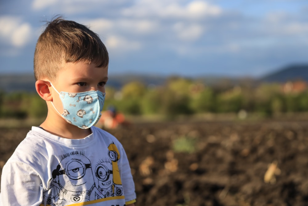 bambino in camicia girocollo bianca e blu con ciuccio bianco e blu