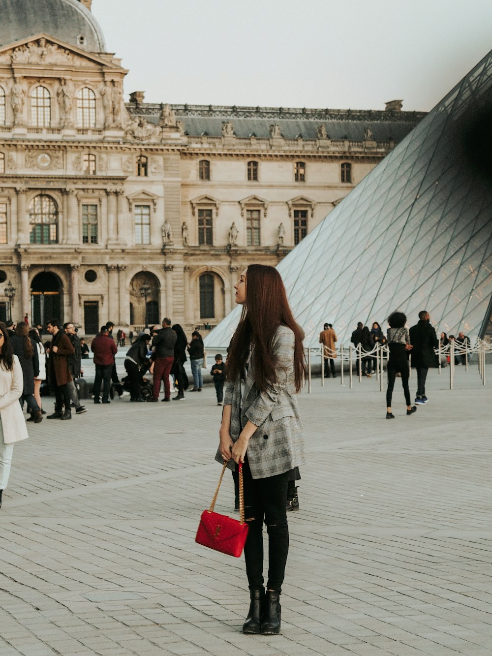 woman in gray coat walking on white concrete floor during daytime